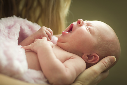 Gentle Hands of Mother Holding Her Precious Newborn Baby Girl.